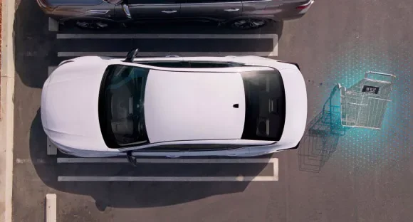 Top view of a white 2027 Nissan Altima in a parking lot with rear sensors detecting a shopping cart behind it at Rob Green Nissan in Twin Falls ID